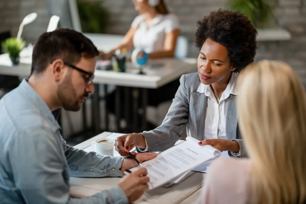 Advogado e cliente analisando documentos em uma reunião, com atendimento jurídico para orientar sobre a venda de precatório e necessidade de advogado para vender precatório.Advogado e cliente analisando documentos em uma reunião, com atendimento jurídico para orientar sobre a venda de precatório e necessidade de advogado para vender precatório.